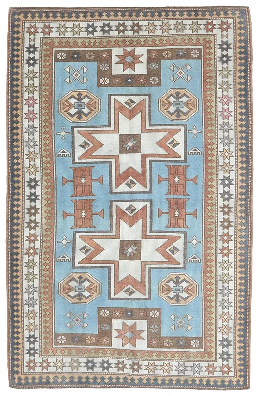 Full top view of the 4'4" x 6'9" vintage Anatolian rug with blue, rust, and ivory geometric patterns