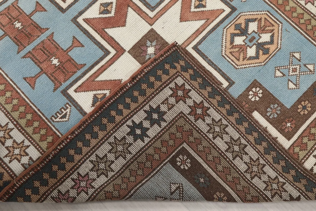 Folded corner of the rug, revealing the thickness of the wool pile and the hand-knotted construction