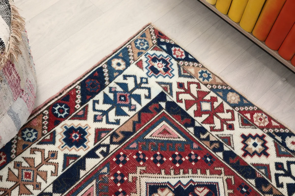 Angled view of the rug's corner, highlighting the diverse tribal patterns in the border