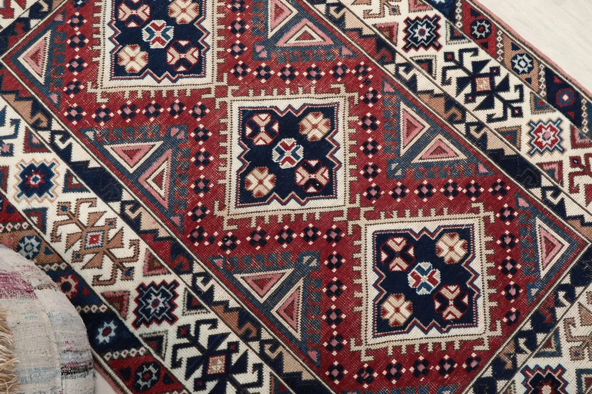 Overhead detail of the central red field with navy diamond motifs and surrounding geometric elements