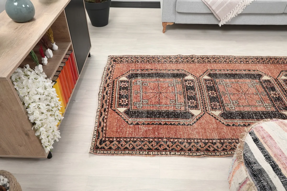 Perspective view of the rust runner rug in a room, showing its placement relative to furniture.