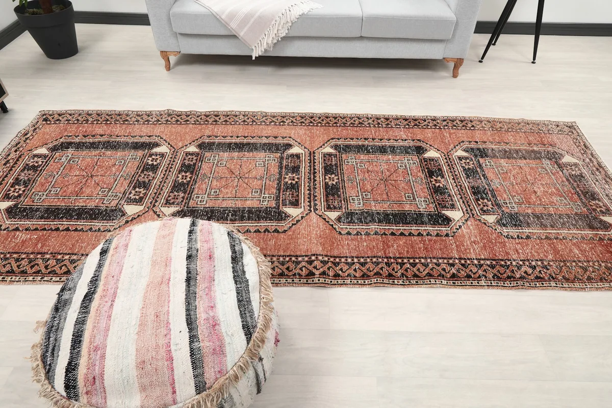 Full view of the rug laid out in a room, emphasizing its long runner shape and pattern.