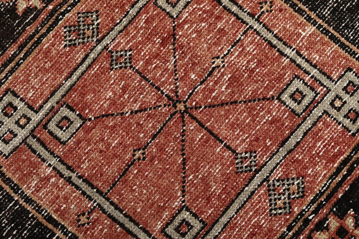 Extreme close-up of the intricate geometric motifs and color variations within a rug panel.