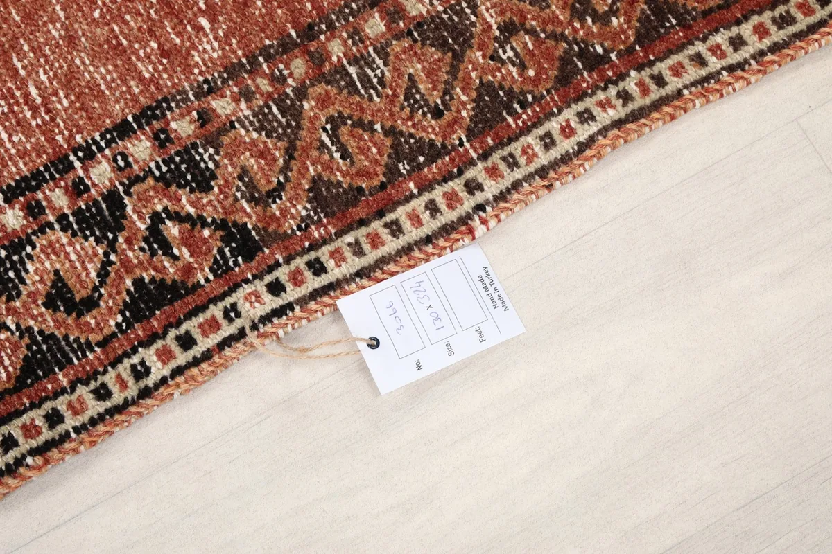Close-up of the rug's edge with a product tag, displaying the weave and border design.
