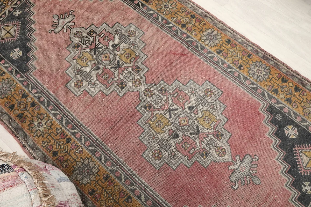 Overhead angle shot showcasing the central geometric medallion and rose field of the rug.
