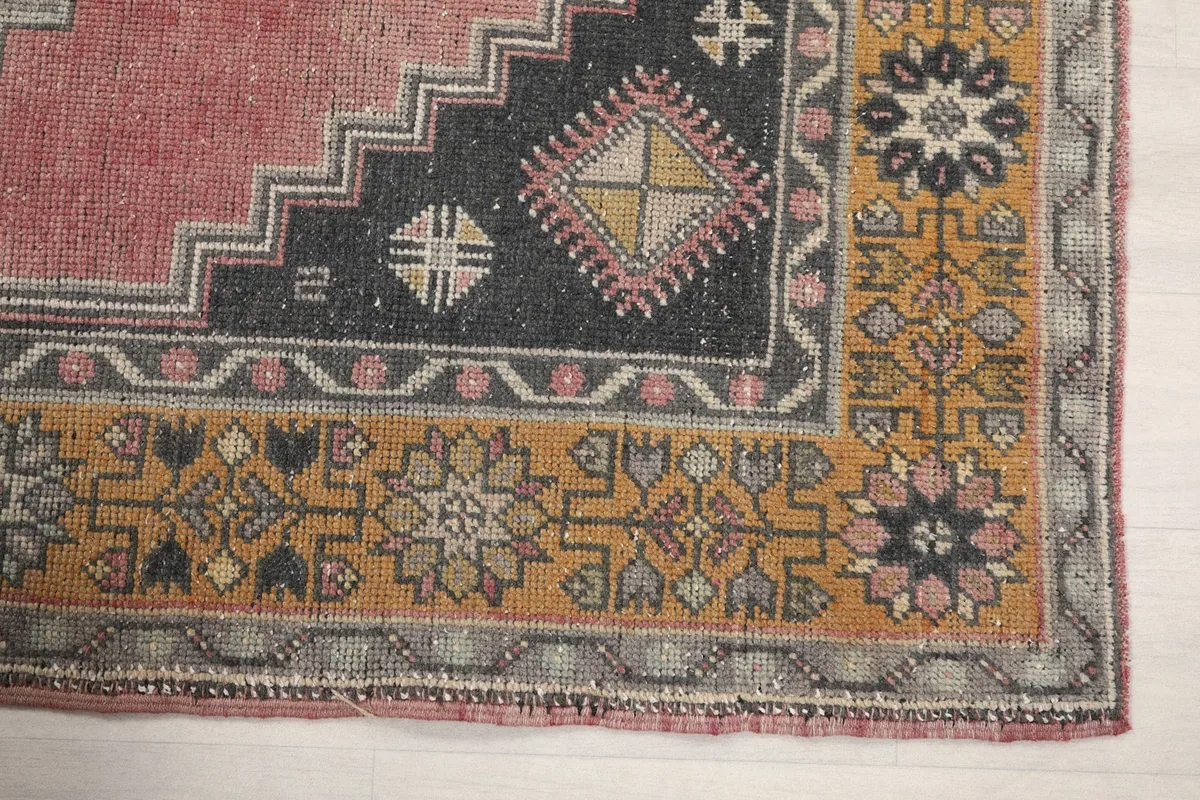 Detailed view of the gold border with floral patterns and the navy inner border of the rug.