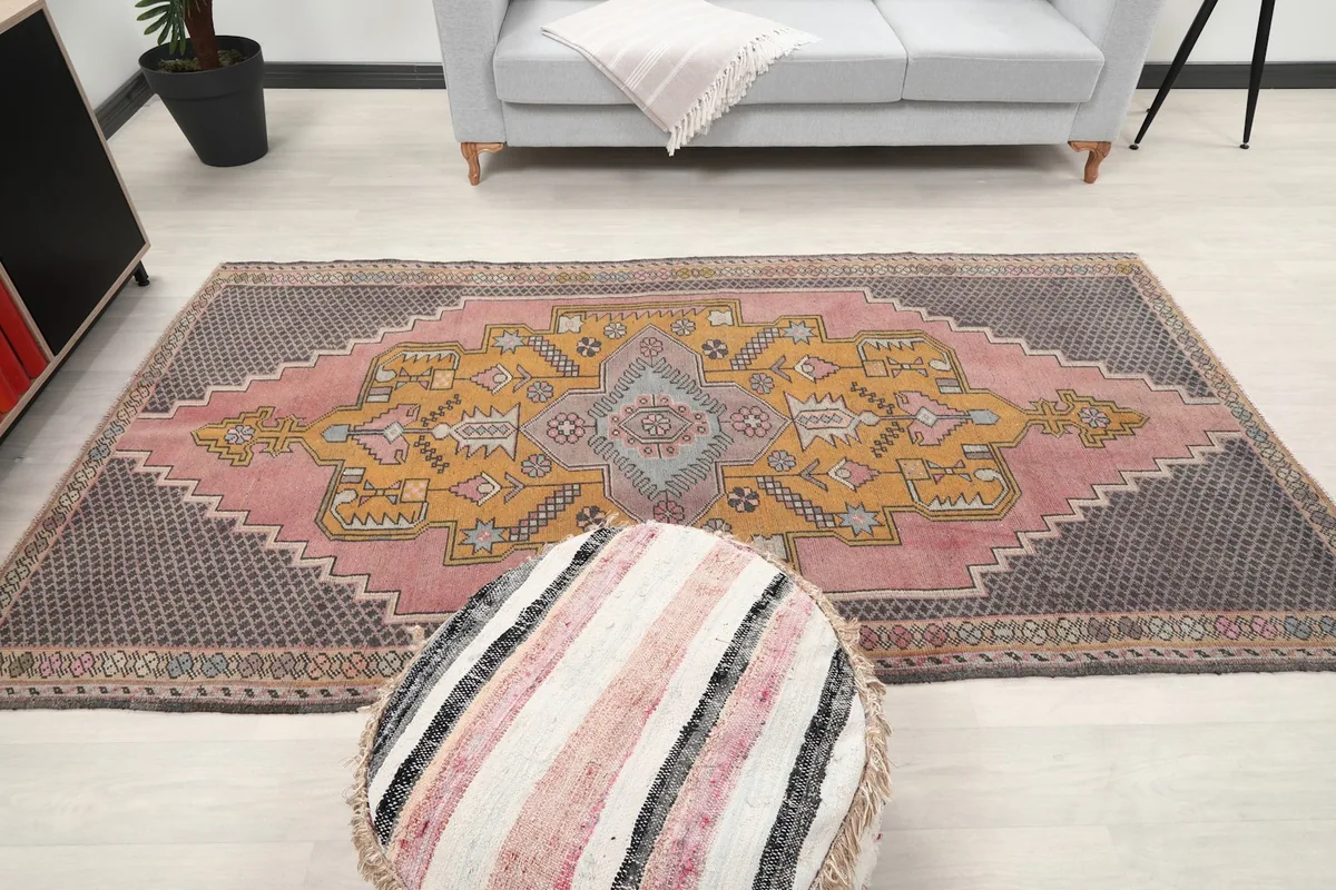 Frontal view of the rug and a striped ottoman in a minimalist living room
