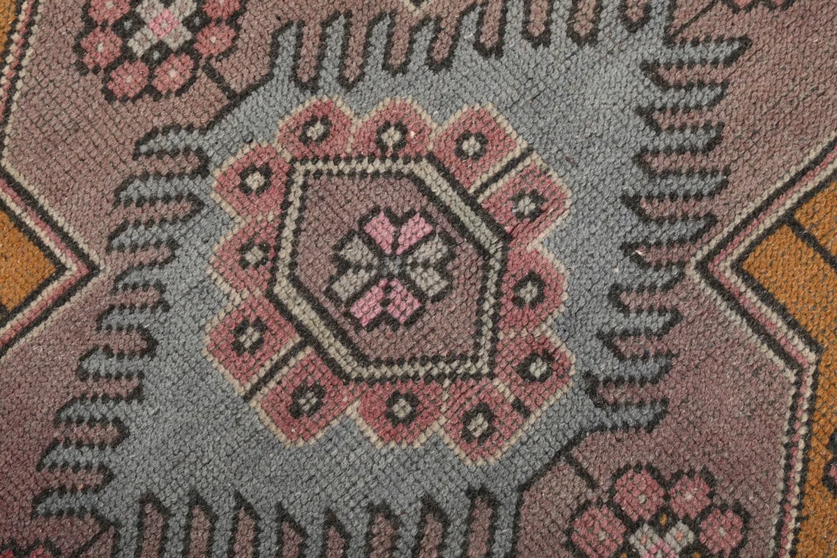 Macro detail of the central blue and rose geometric patterns within the medallion