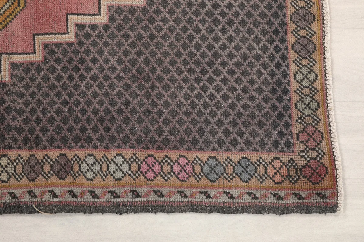 Detail of the charcoal border with intricate geometric patterns and multicolor accents