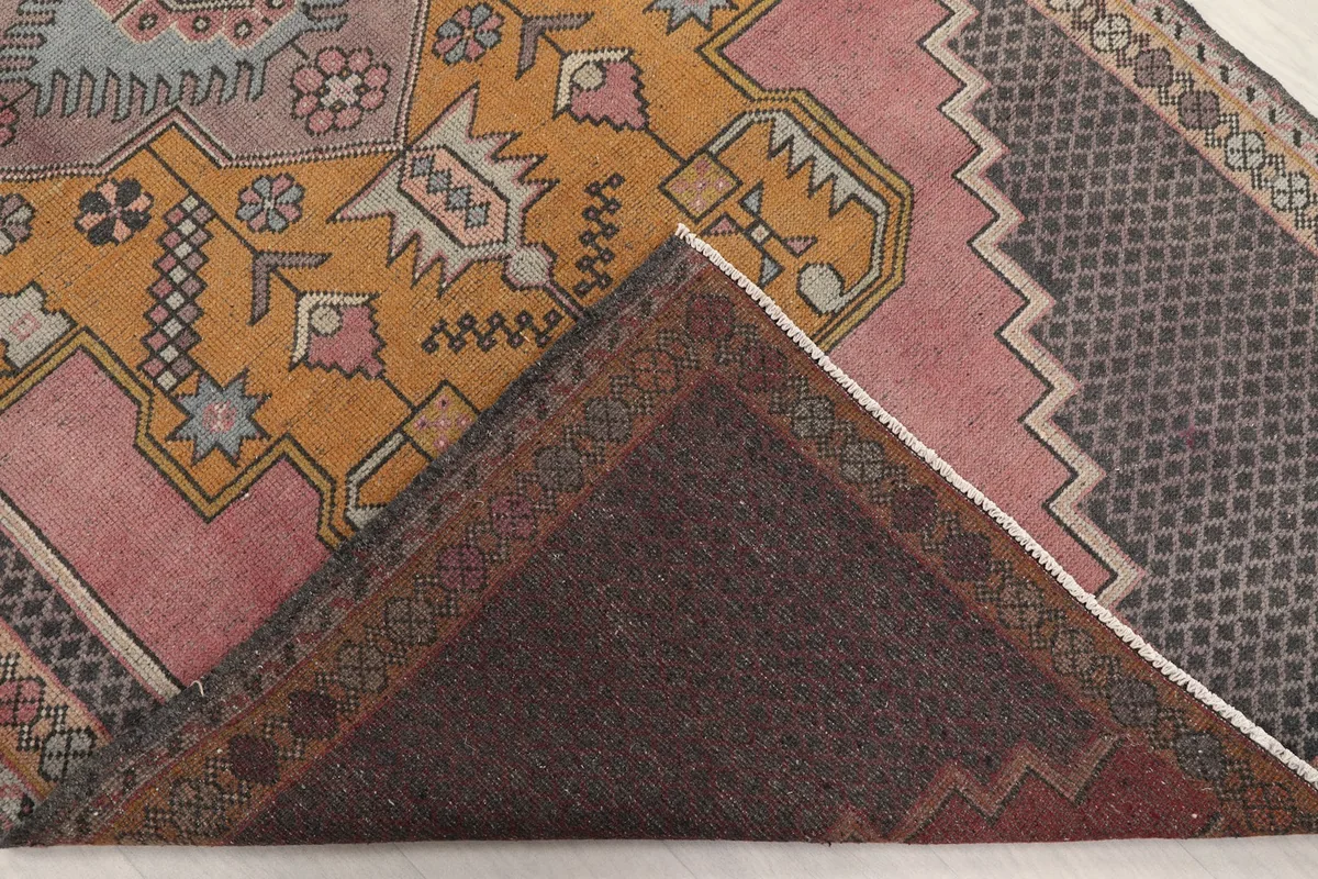 Folded corner revealing the hand-knotted wool pile and cotton foundation of the rug