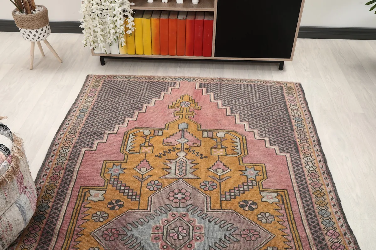 Overhead view of the vintage rug in a room, highlighting the rose field and gold medallion