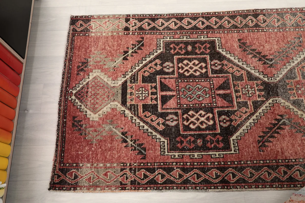 View of the runner rug from above, focusing on the blend of rose, charcoal, and beige colors