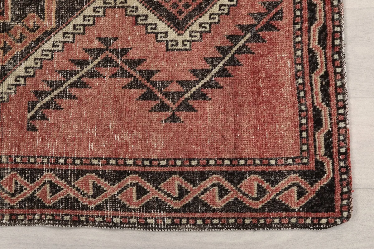 Detail of the border design on the vintage Anatolian runner rug, showing charcoal and beige patterns