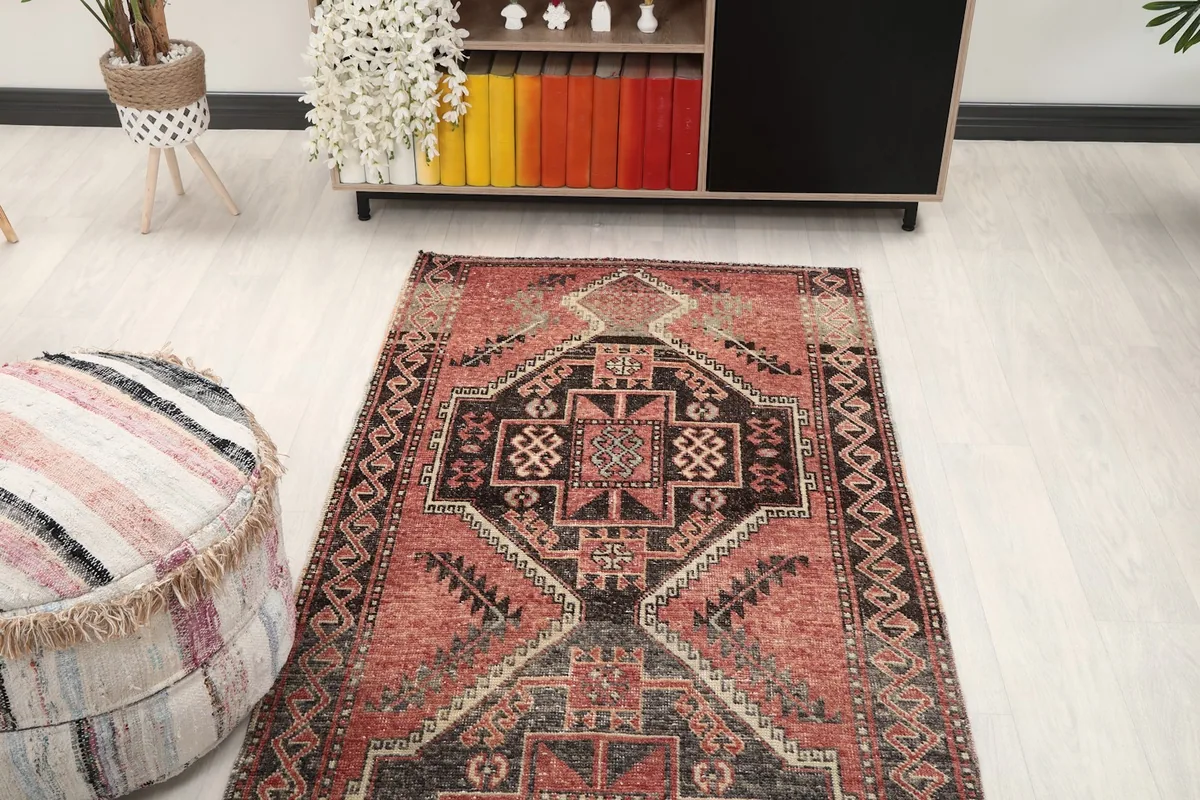 Overhead view of the rose and charcoal runner rug from one end, showing its full design