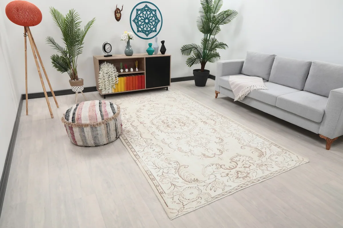 Angle view of the ivory and tan rug in a living space, showing its placement relative to furniture