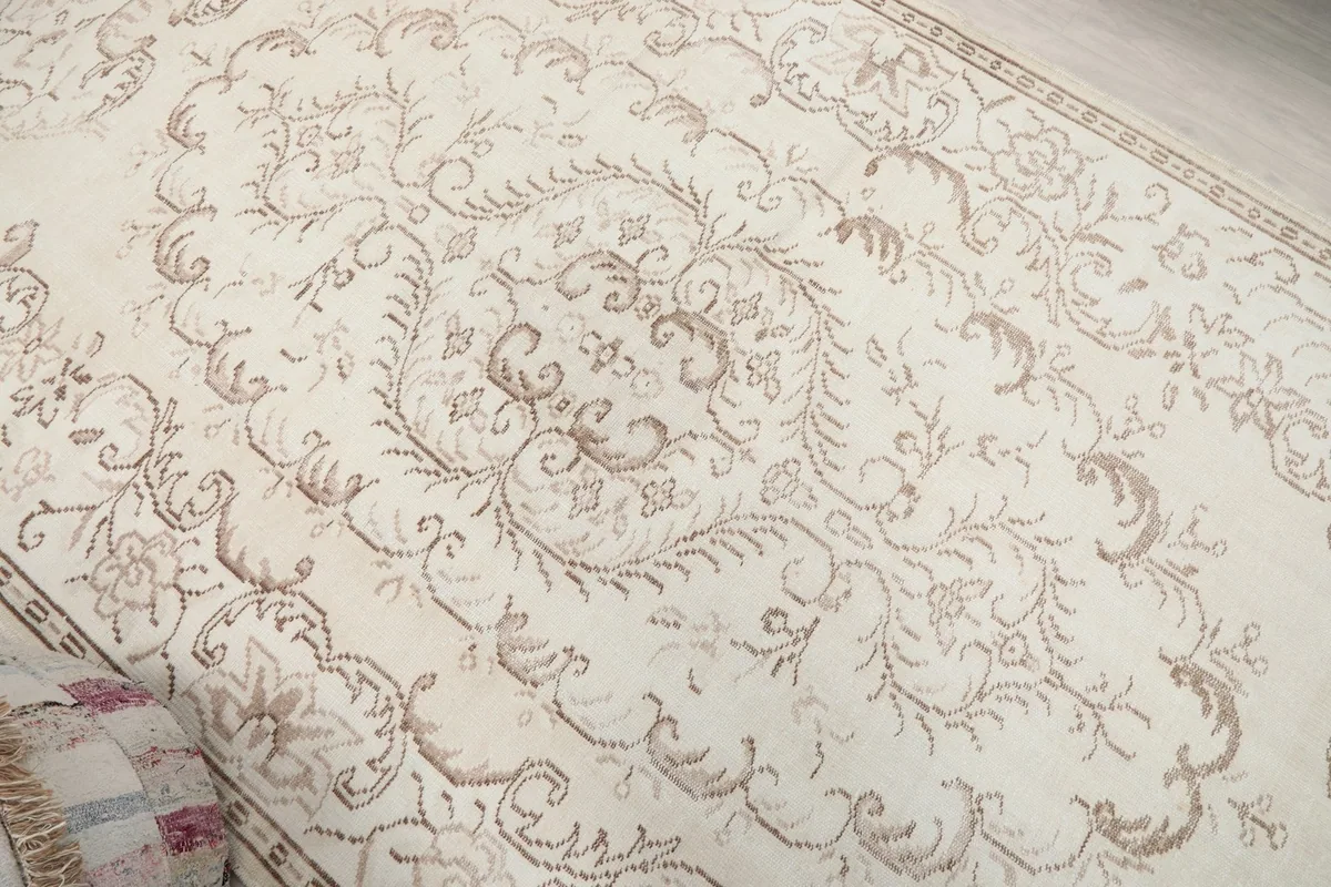 Close-up of the central medallion and surrounding tan floral patterns on the ivory field