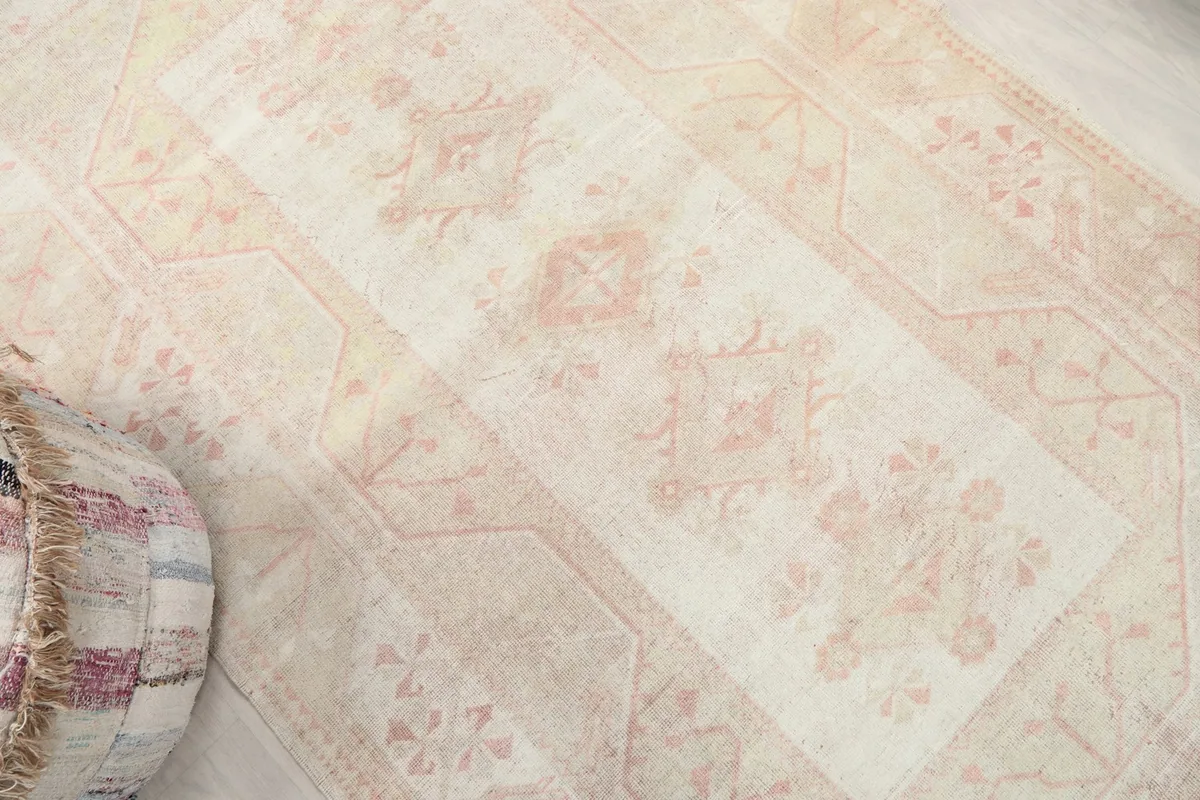 Overhead angled shot highlighting the central medallion and surrounding patterns of the rug