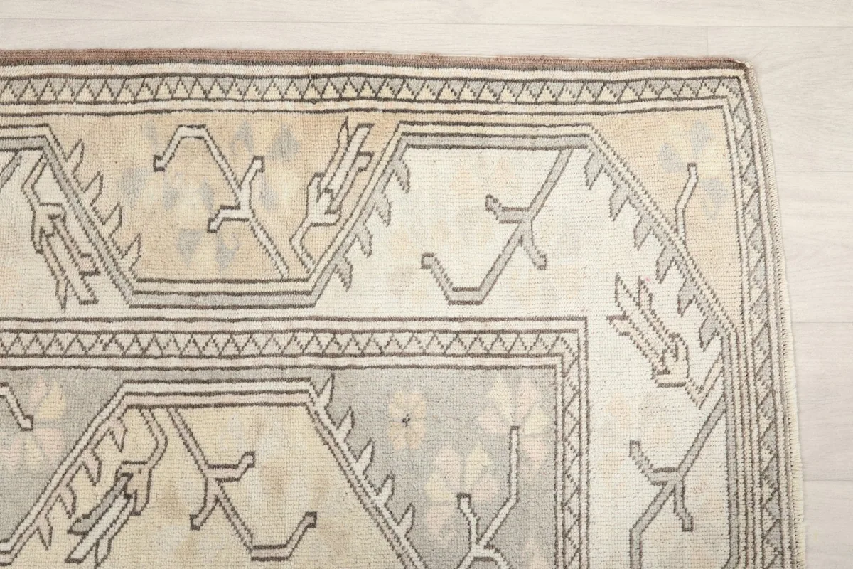 Detail of the rug's outer border with gray tribal motifs