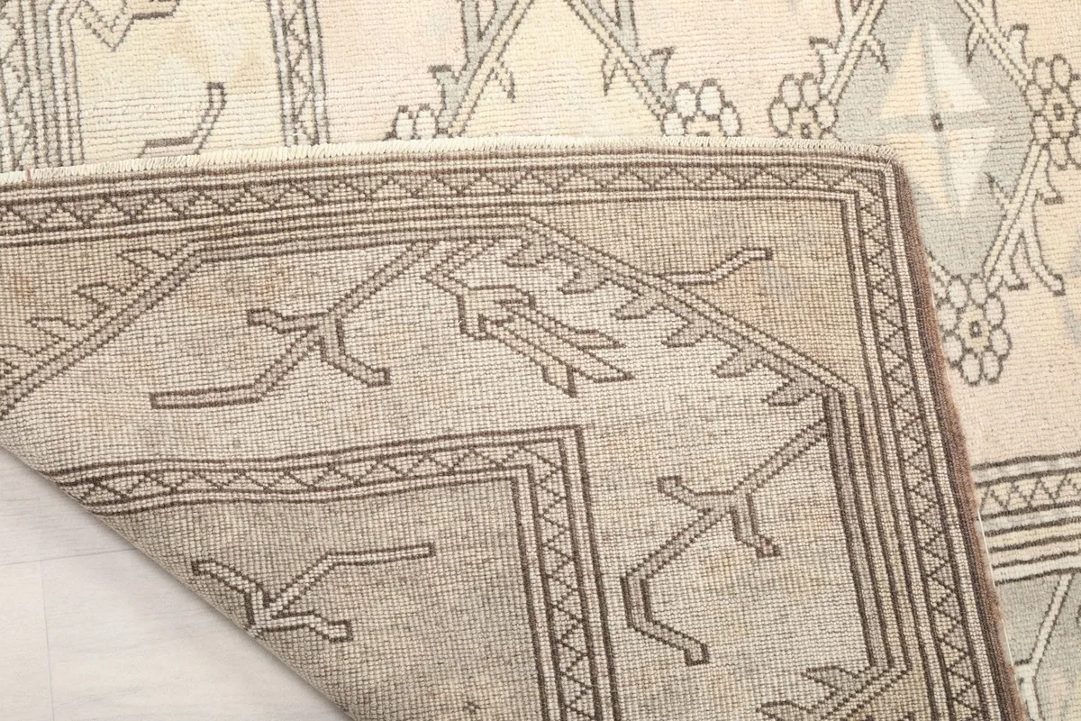 Corner of the rug lifted to show the back and weave structure
