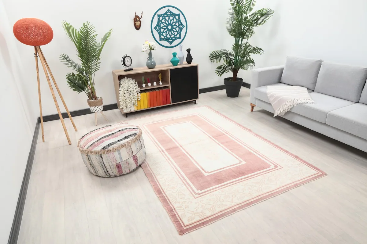 Angle view of the rose and ivory rug in a modern living space with light flooring