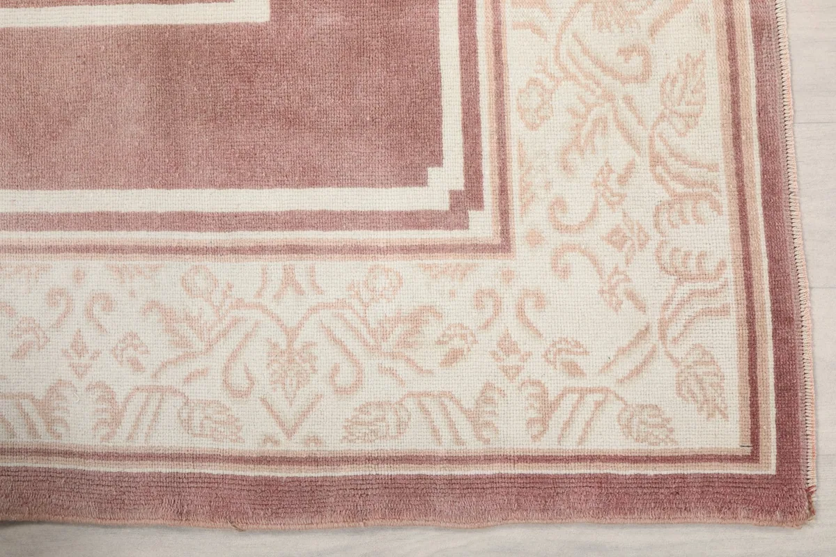 Detail of the ivory border with faded rose floral and geometric motifs