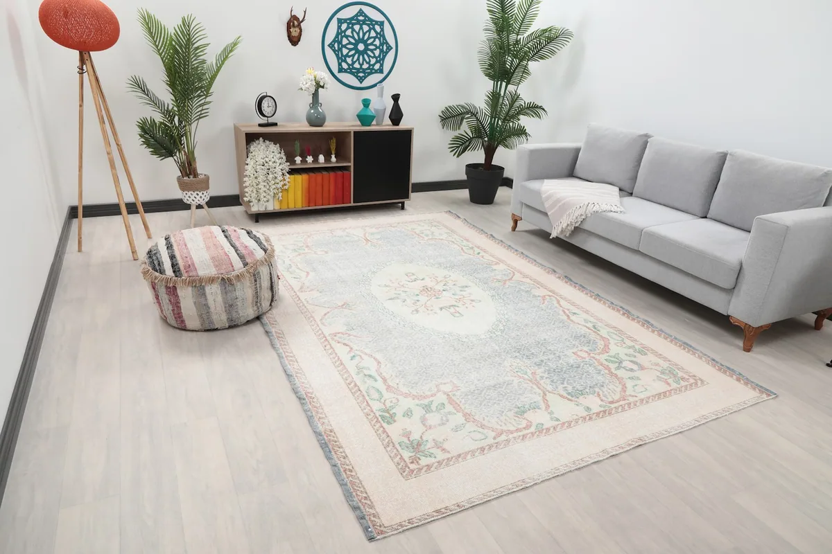 Angled view of the large ivory and blue floral rug in a modern living space