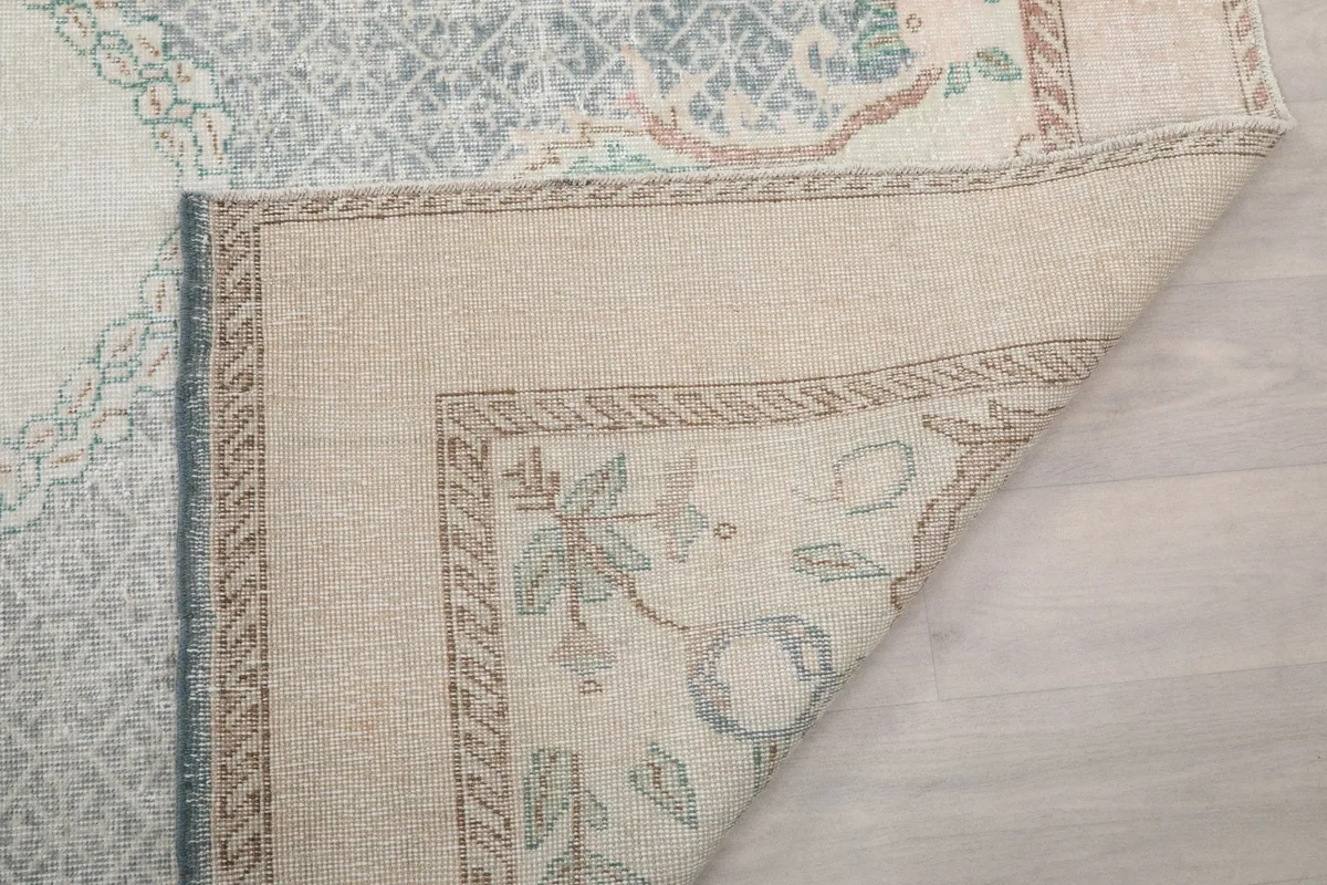 Close-up of the folded rug corner, showing the wool pile and integrity of the vintage construction