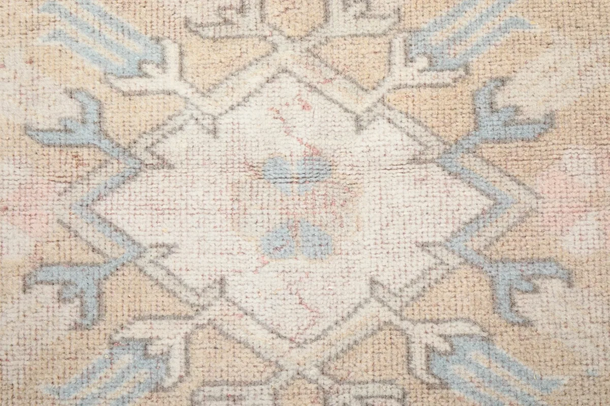 Close-up of a central geometric motif on the rug, showing the hand-knotted wool texture