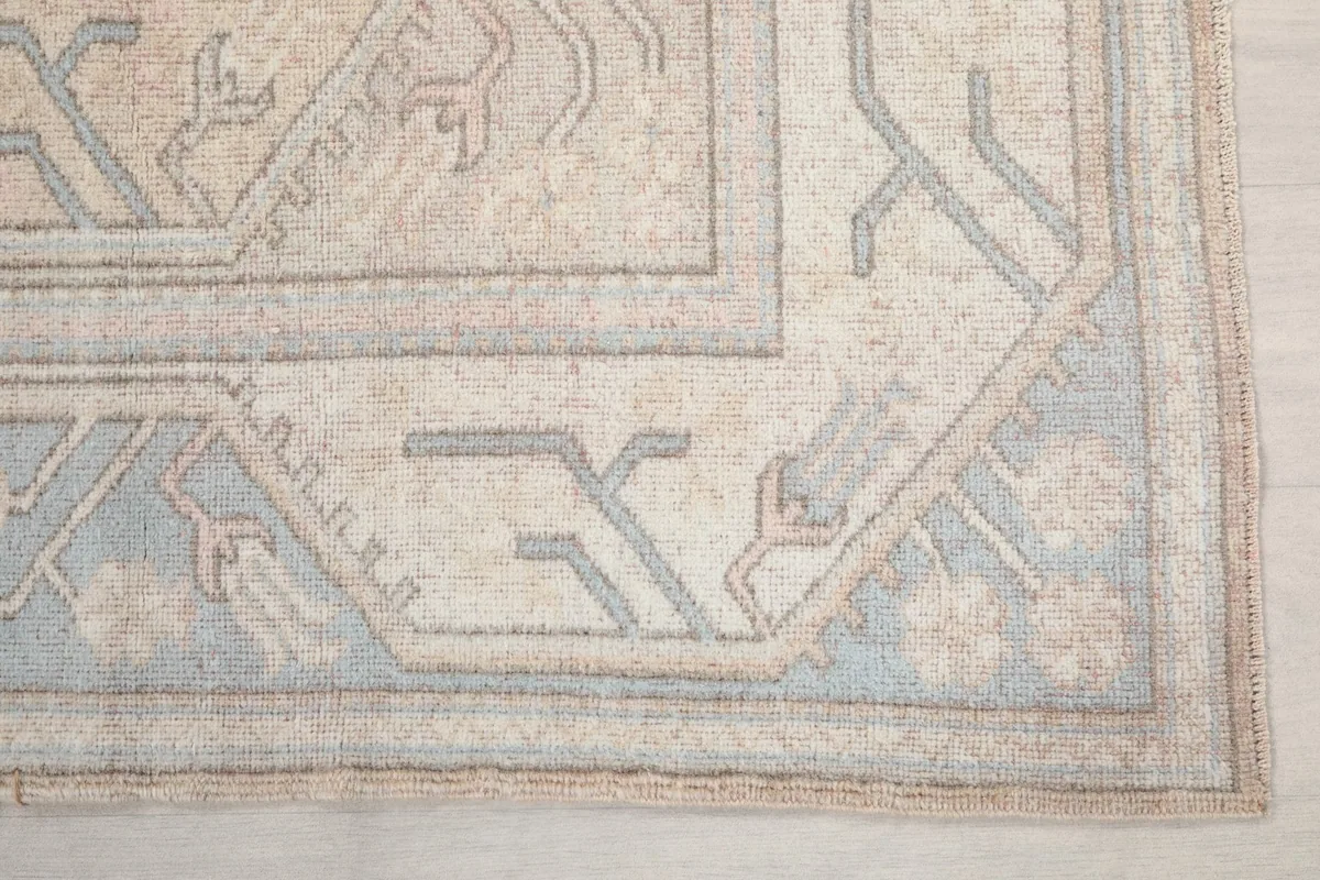 Detail of the rug's border design featuring blue and beige geometric patterns