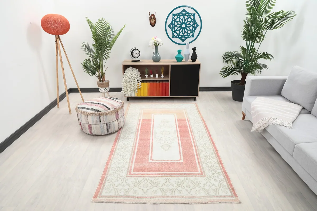 Vintage Anatolian rug in a living room setting with a light sofa and wooden furniture, showing its overall placement.