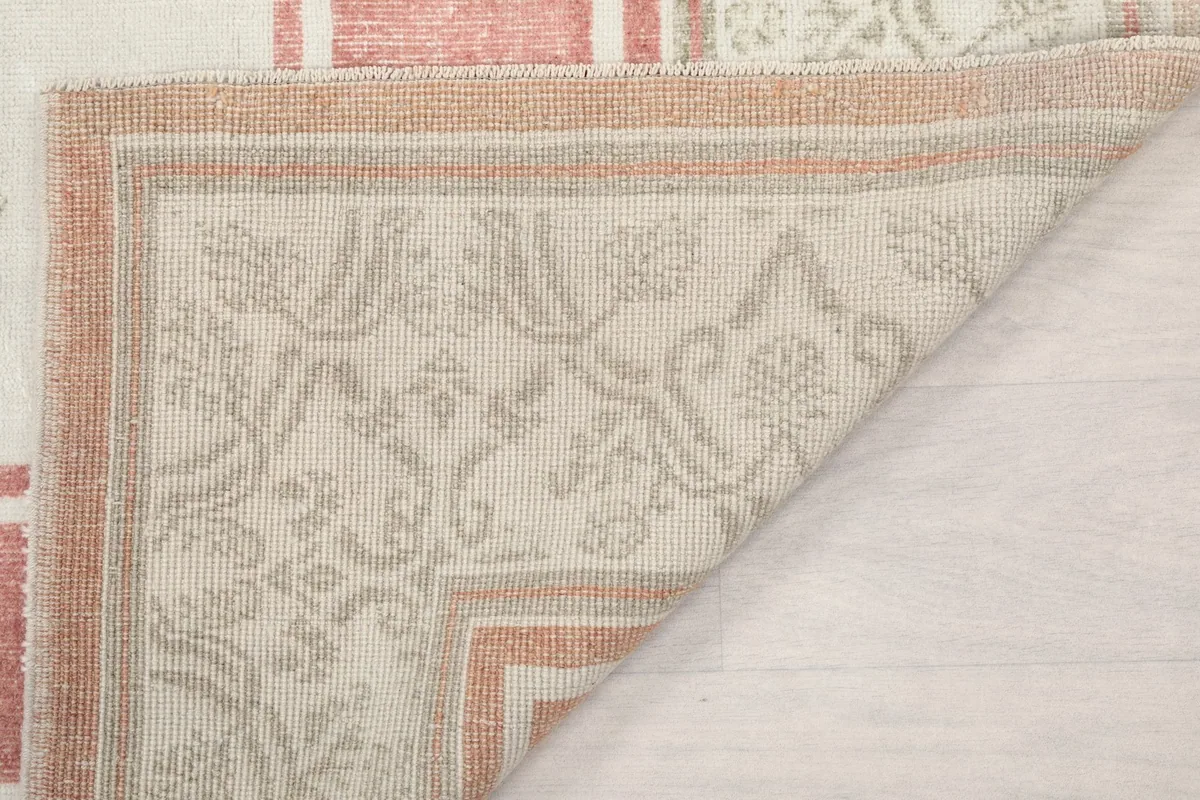 Underside view of a folded corner, showing the tightly woven cotton foundation and reverse of the knots.