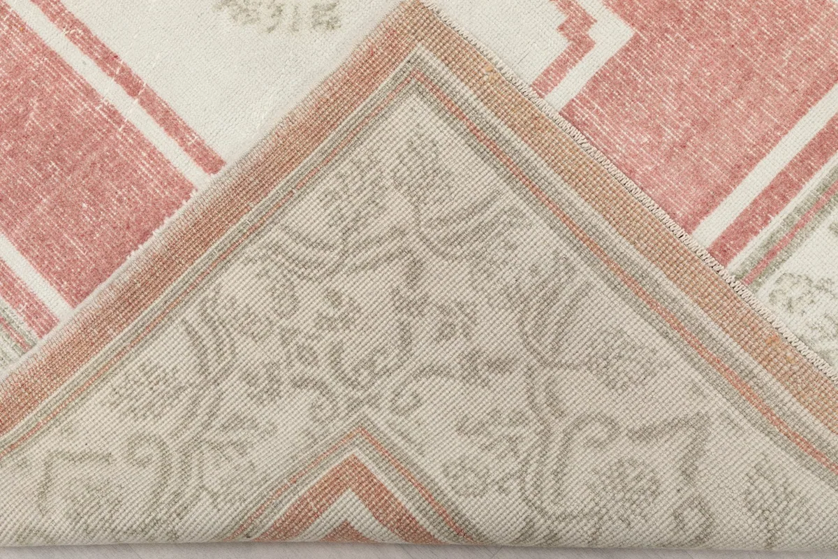 Folded corner of the rug, revealing the hand-knotted wool pile and cotton foundation.
