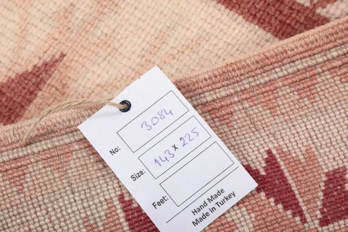 Close-up of the rug's back with a tag, showing the hand-knotted cotton foundation