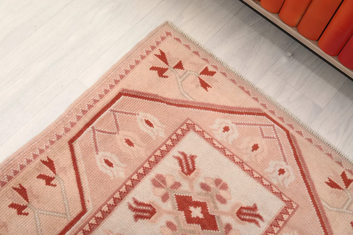 Detailed shot of a corner of the rug, highlighting the geometric border and inner field patterns