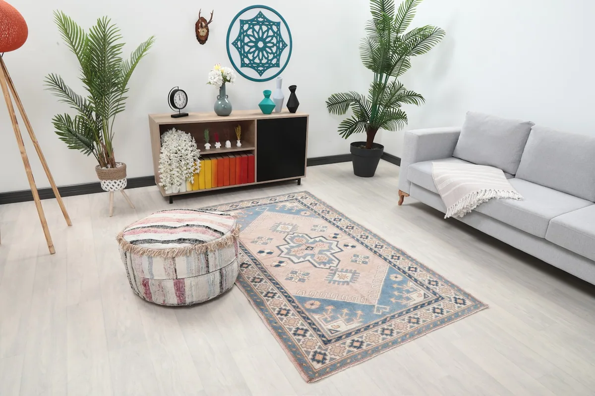 Overhead view of the rug in a living room, showing its position relative to a sofa and decorative pouf.