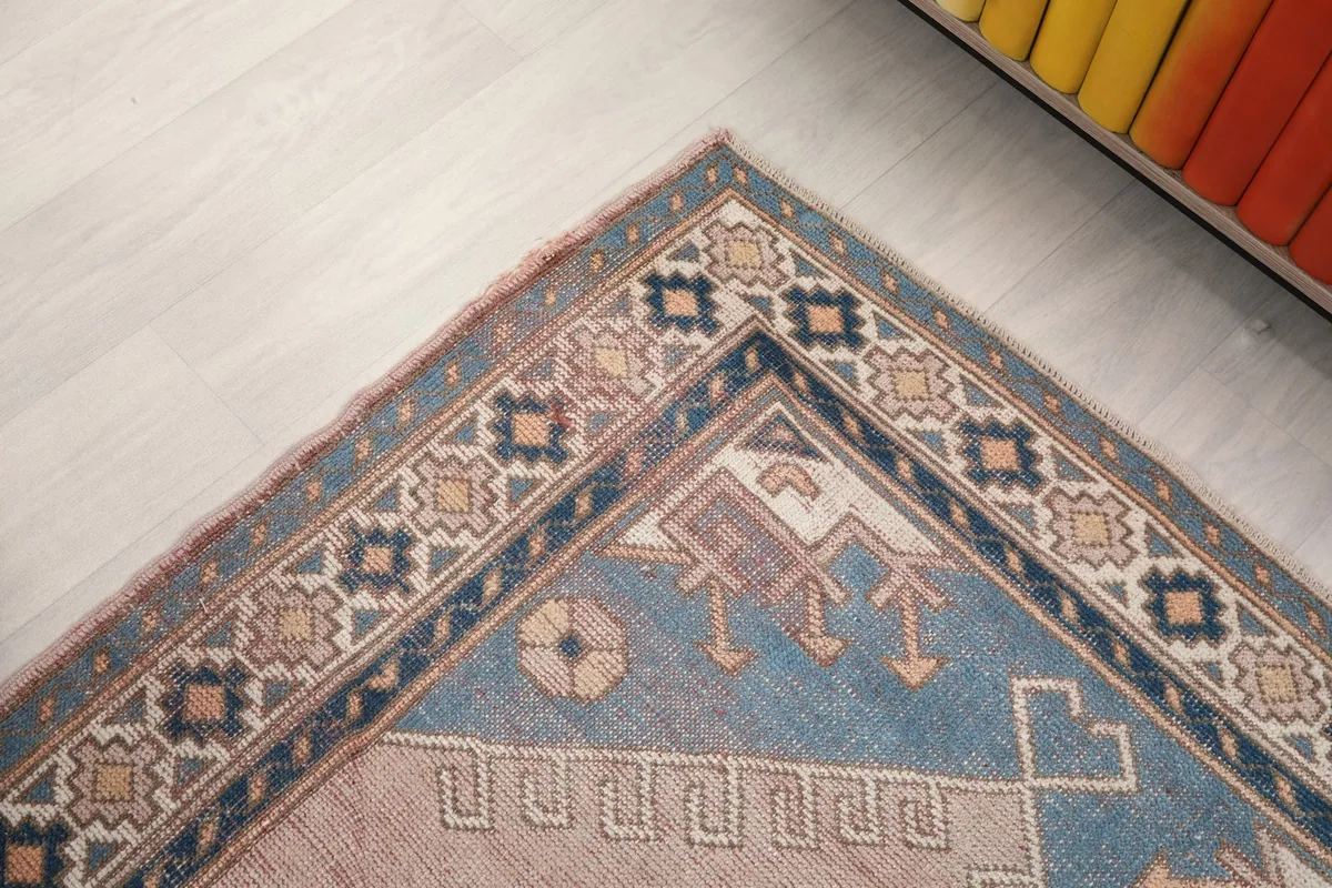 Close-up of the rug's border, showcasing the repeating patterns and color palette.