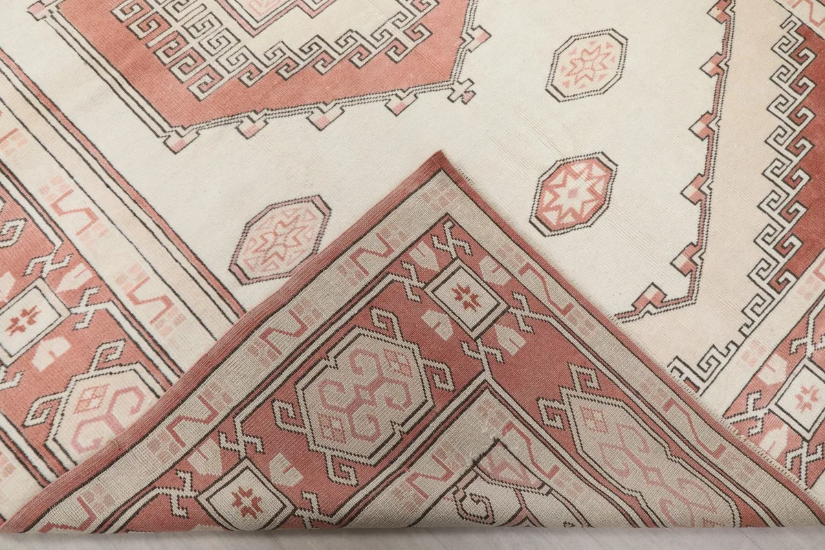 Corner of the rug folded back to show the hand-knotted wool pile and cotton foundation