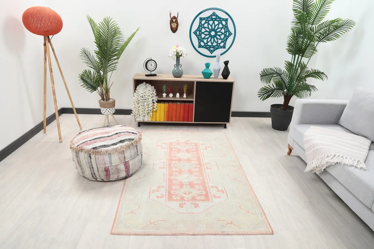 Vintage cream and pink rug placed in a modern living room setting