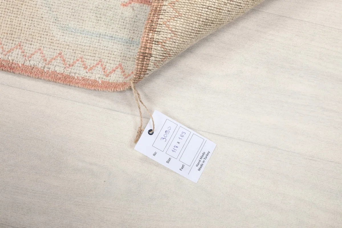 Close-up of the rug's tag displaying its dimensions in centimeters and inches