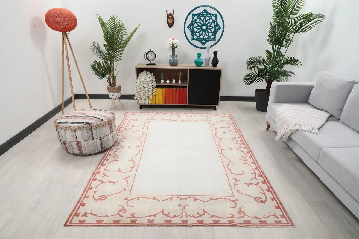 Vintage ivory and rose Anatolian rug displayed in a modern living room setting.