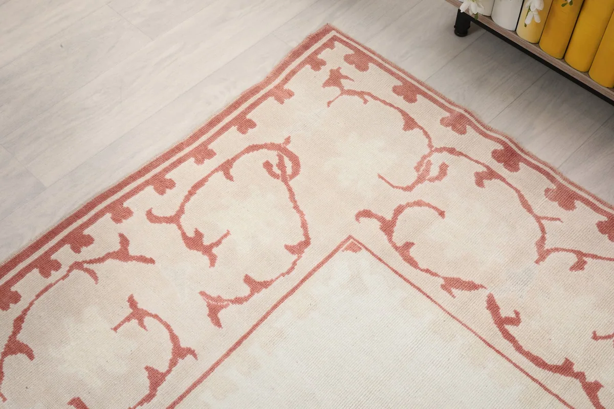 Corner detail of the rug's rose border, showing the intricate vine-like patterns.