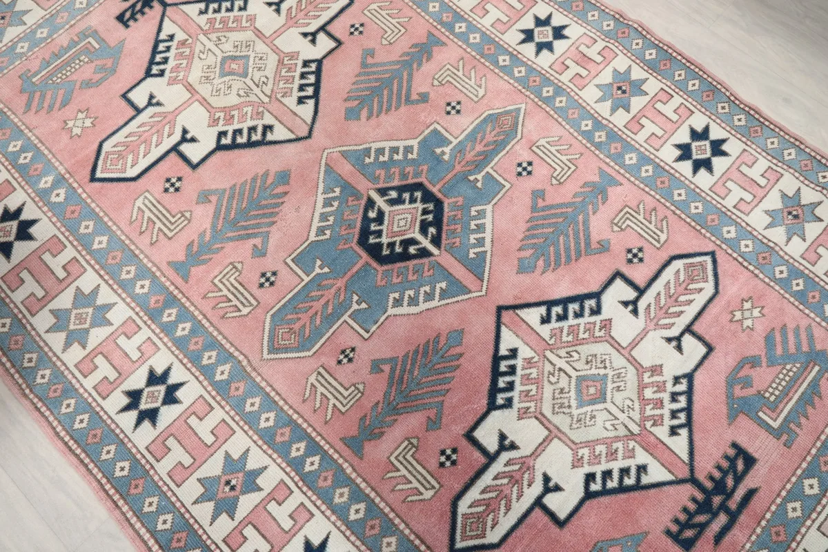 Angled close-up of the central blue and navy geometric medallion on the rose field