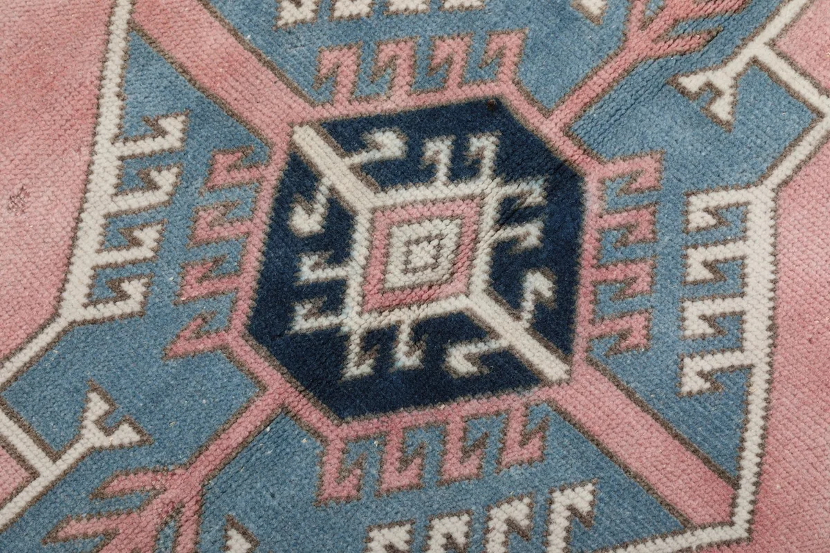 Detailed view of the low pile and intricate knotting of the blue and rose patterns