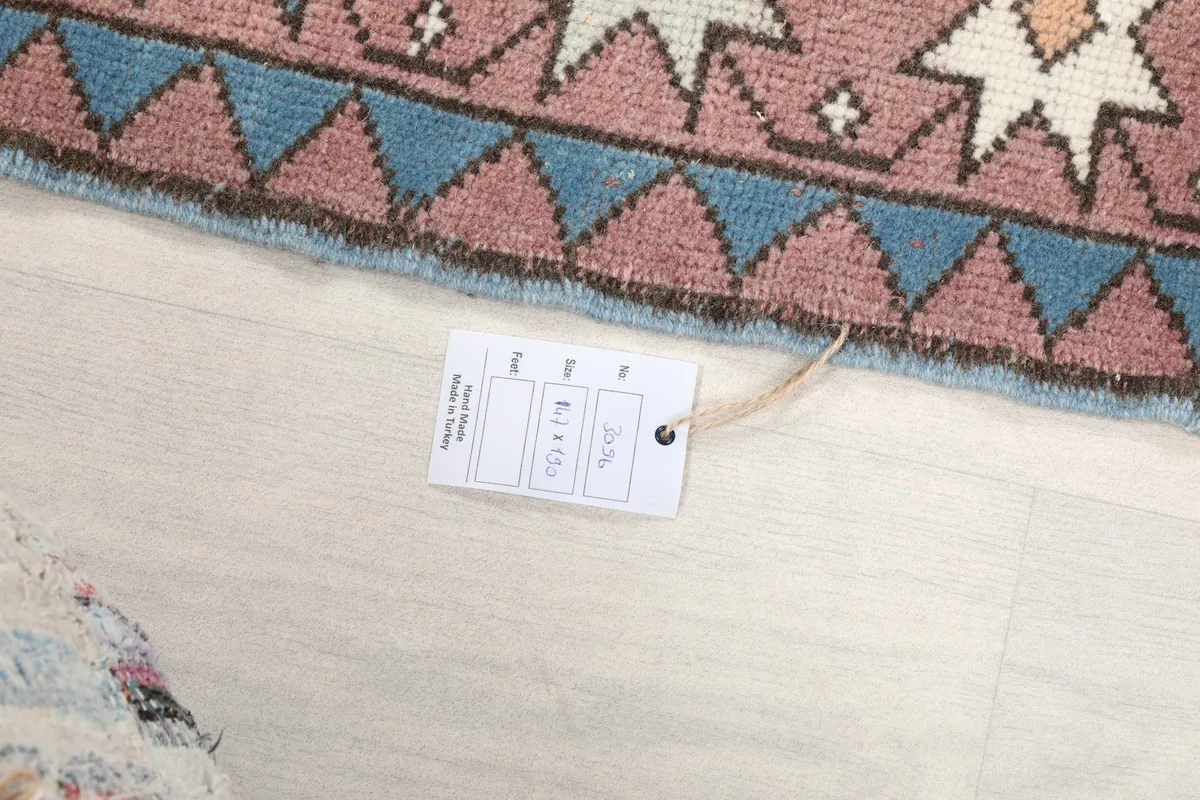 Close-up of the rug's edge and a product tag with size information