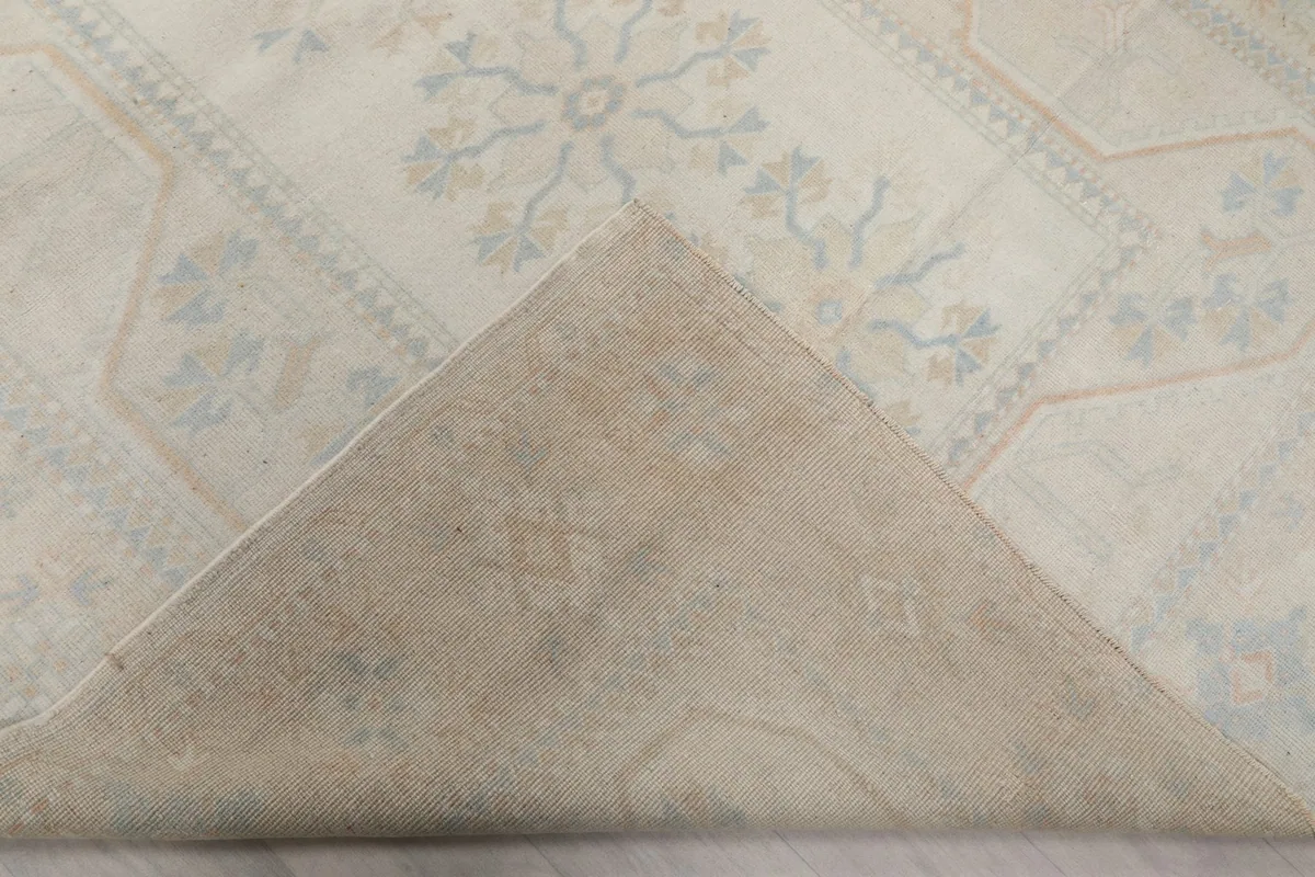 Folded corner of the rug, revealing the reverse side and foundation
