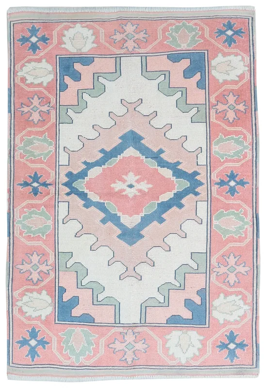 Full top view of the rose and ivory geometric Anatolian rug on a white background