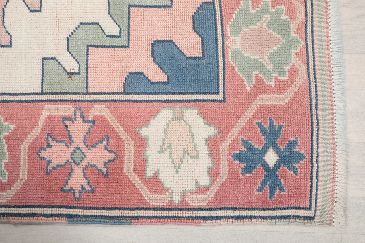Close-up detail of the rose border with blue and green geometric motifs