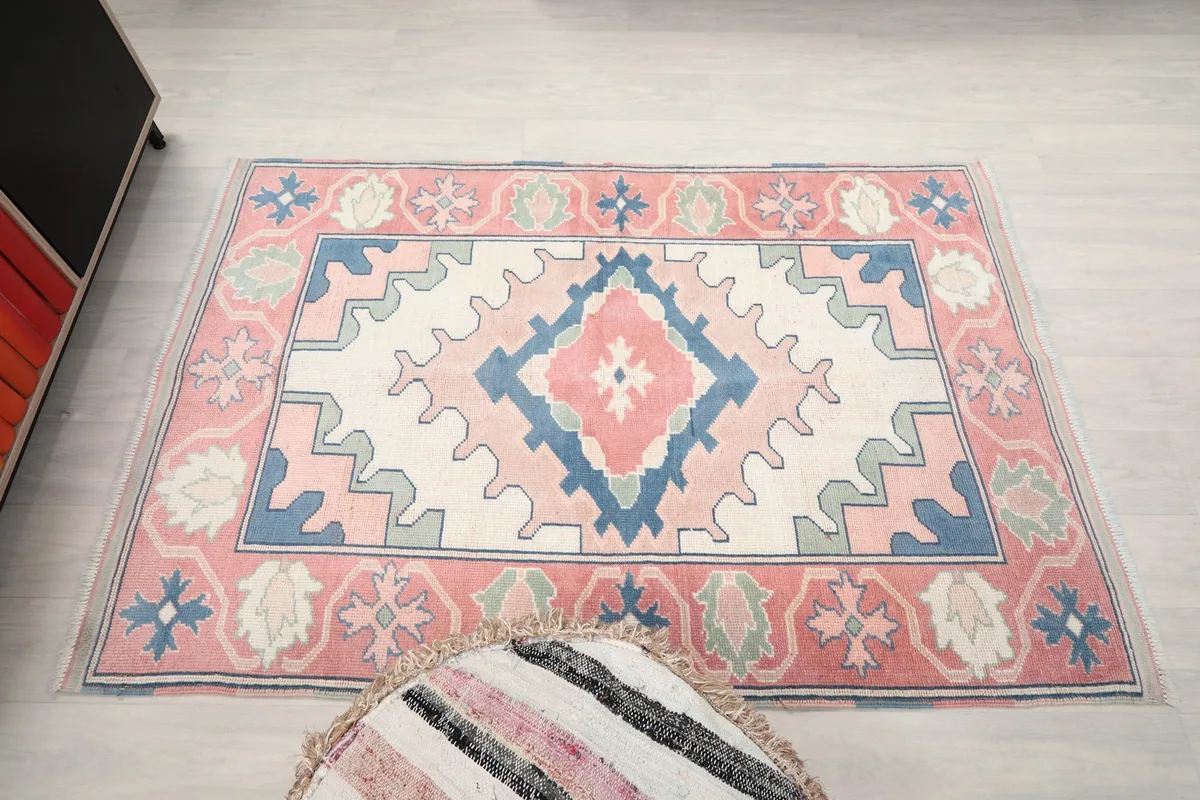Direct overhead shot of the rose and ivory rug, showcasing its full geometric design