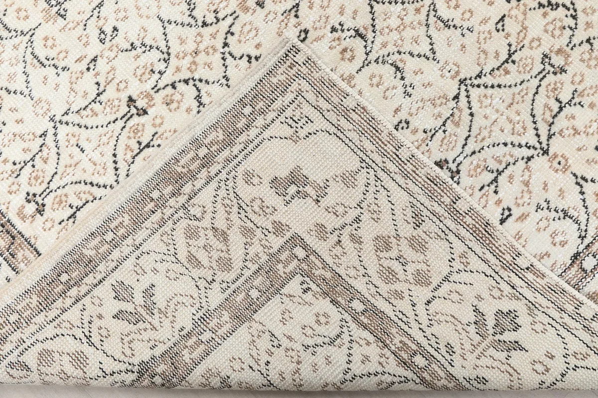 Folded corner of the rug, revealing the wool pile and cotton foundation construction