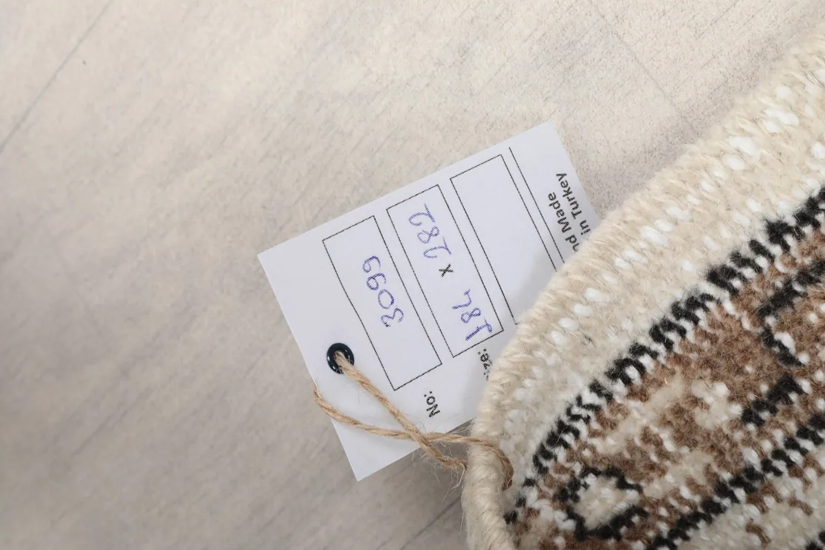 Close-up of the product tag attached to the rug, showing its dimensions and origin